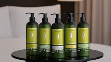 Cinco botellas de Verveine L'OCCITANE sobre una mesa en una habitación de hotel.