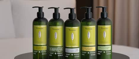 Cinco botellas de Verveine L'OCCITANE sobre una mesa en una habitación de hotel.