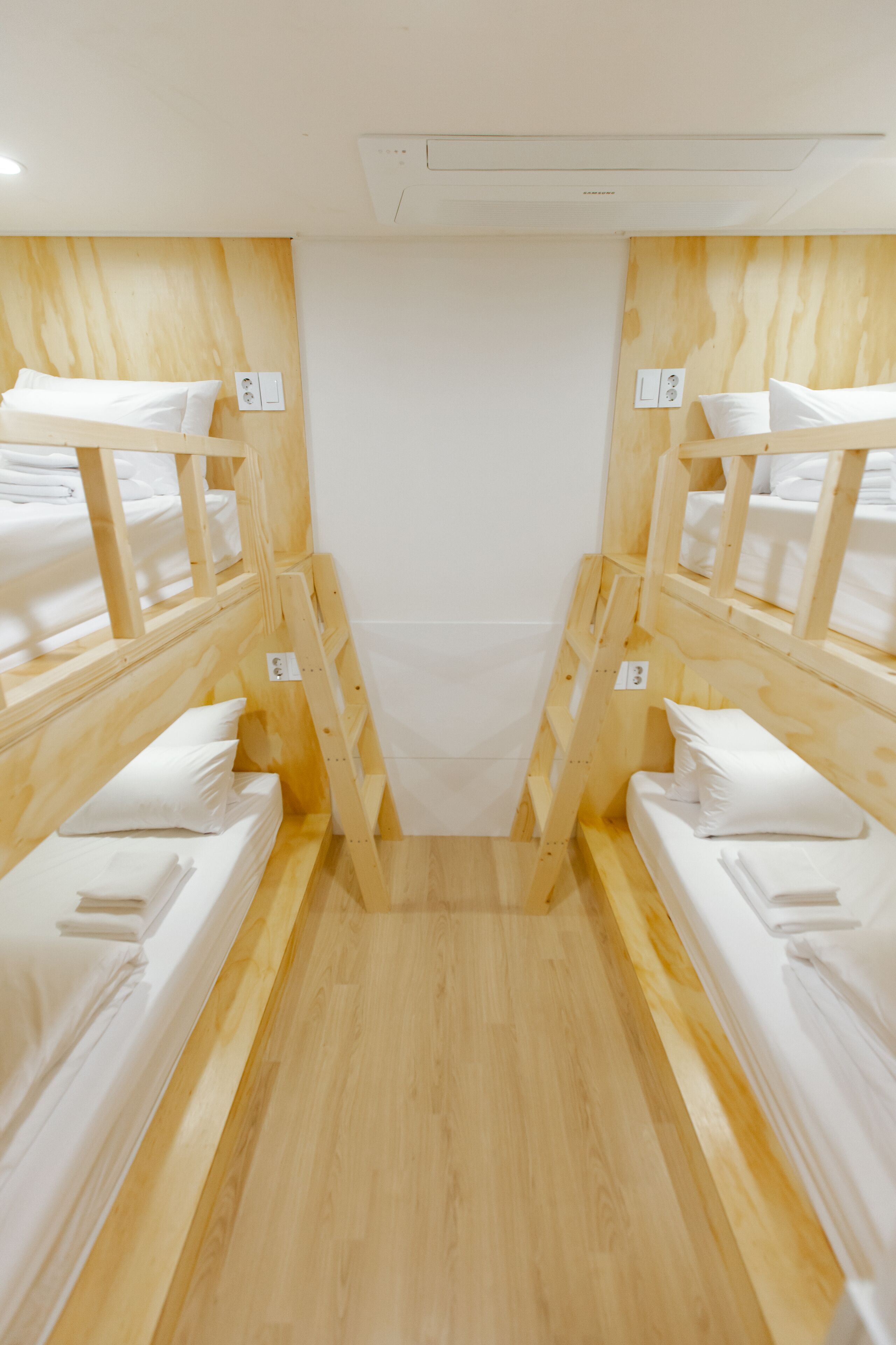 A room with bunk beds, wooden walls, and a white ceiling.