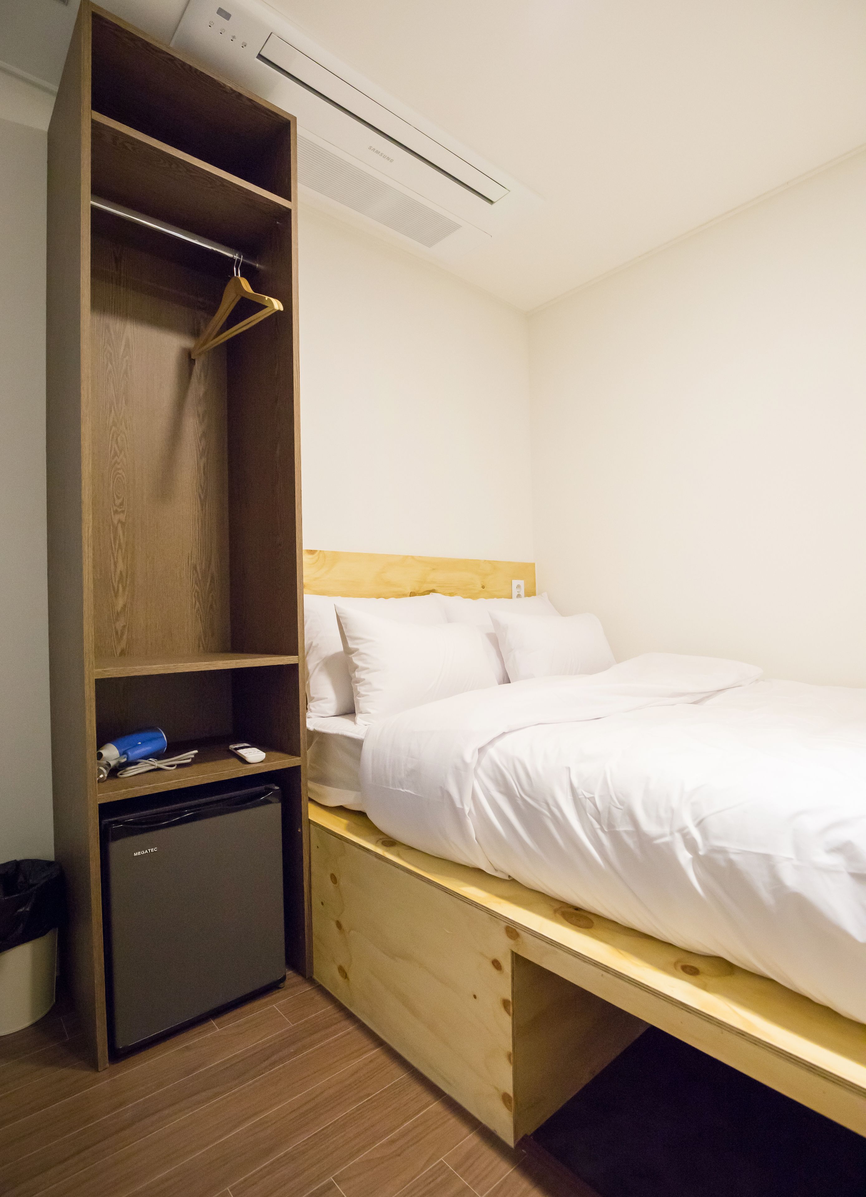 A compact bedroom with a bed, a wardrobe, and a small kitchenette.