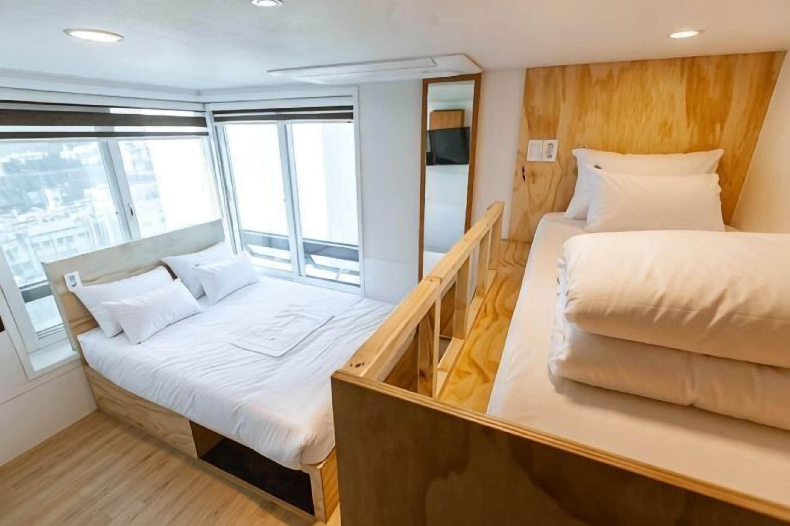 A room with a bed, a window, and a wooden headboard.