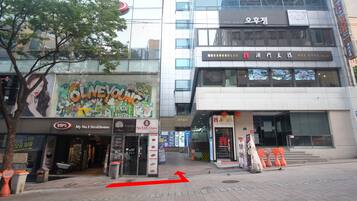 A street view with a restaurant named 'OLNEYONG' and a building with a sign 'My No.1 Steakhouse'.