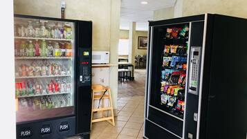 Zona de máquinas expendedoras con dispensador de bebidas y máquina para snacks.