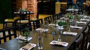A restaurant with a long dining table set with chairs, glasses, and menus. - 950 Condotel (Angeles City)