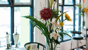 A glass table with a vase of flowers and colorful hanging light fixtures. - 950 Condotel (Angeles City)