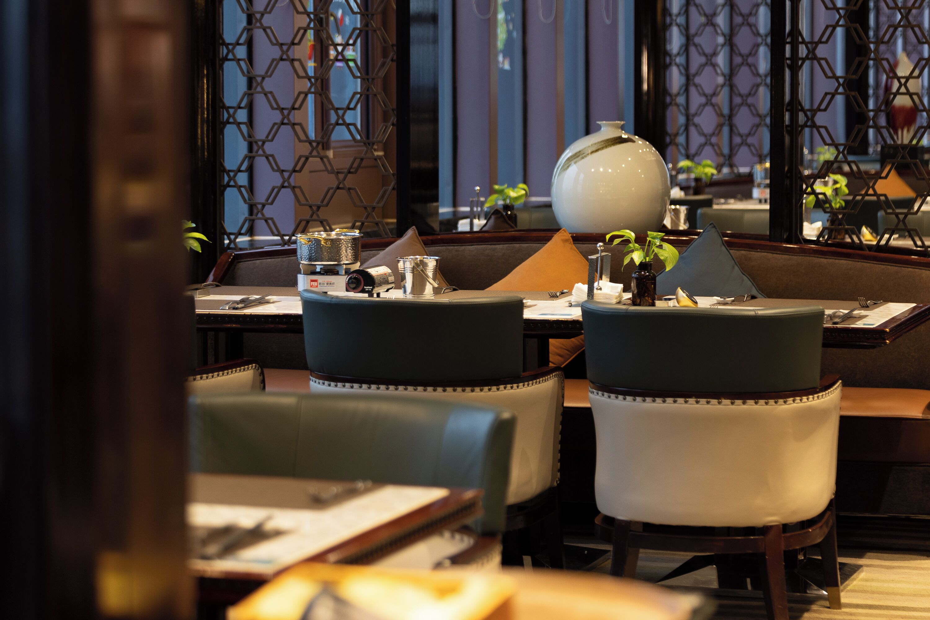 A restaurant interior with tables, chairs, and a decorative lamp.