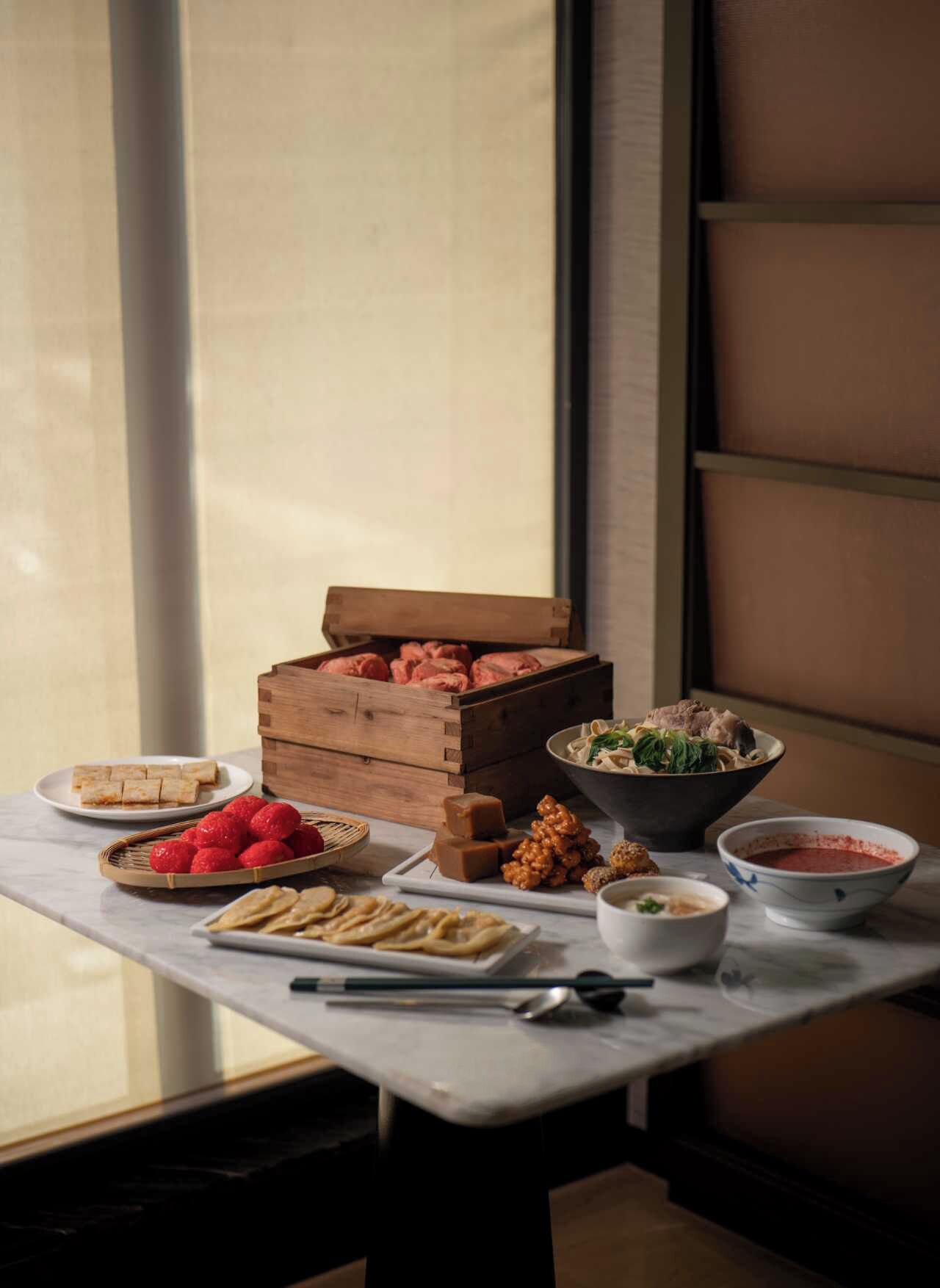 A dining table with various food items and a wooden crate.