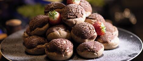 Eine Schale mit Schokoladenbrötchen und Erdbeeren auf einem Tisch.