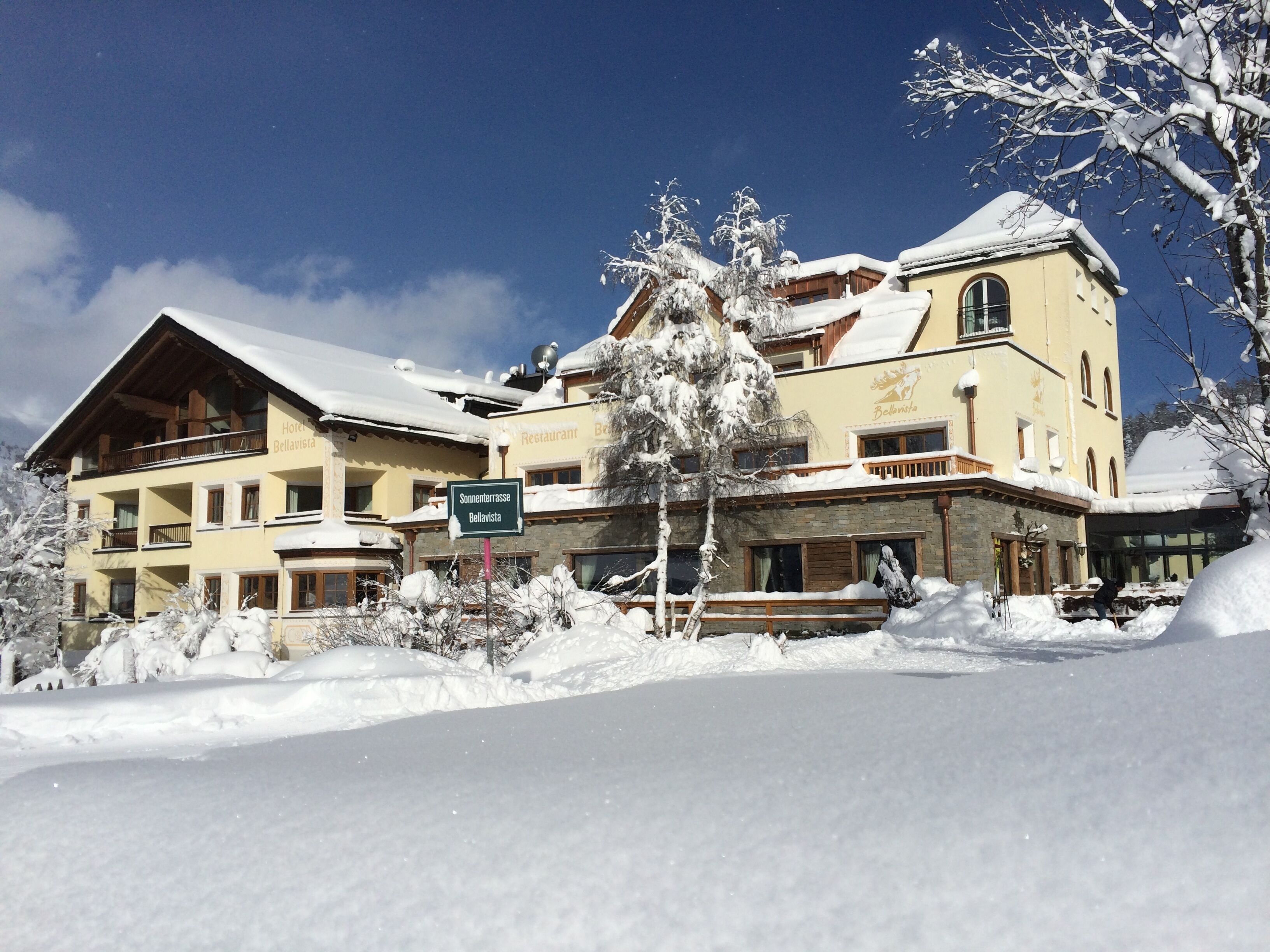 Et hotel med flere balkoner og et skilt, der angiver 'Sommerterrasse Bellavista'.