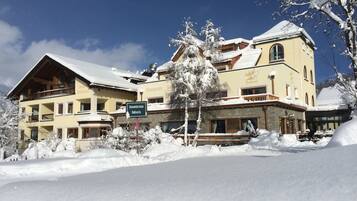 Et hotel med flere balkoner og et skilt, der angiver 'Sommerterrasse Bellavista'.
