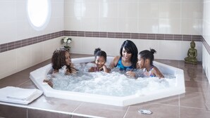 A bathtub with three people.