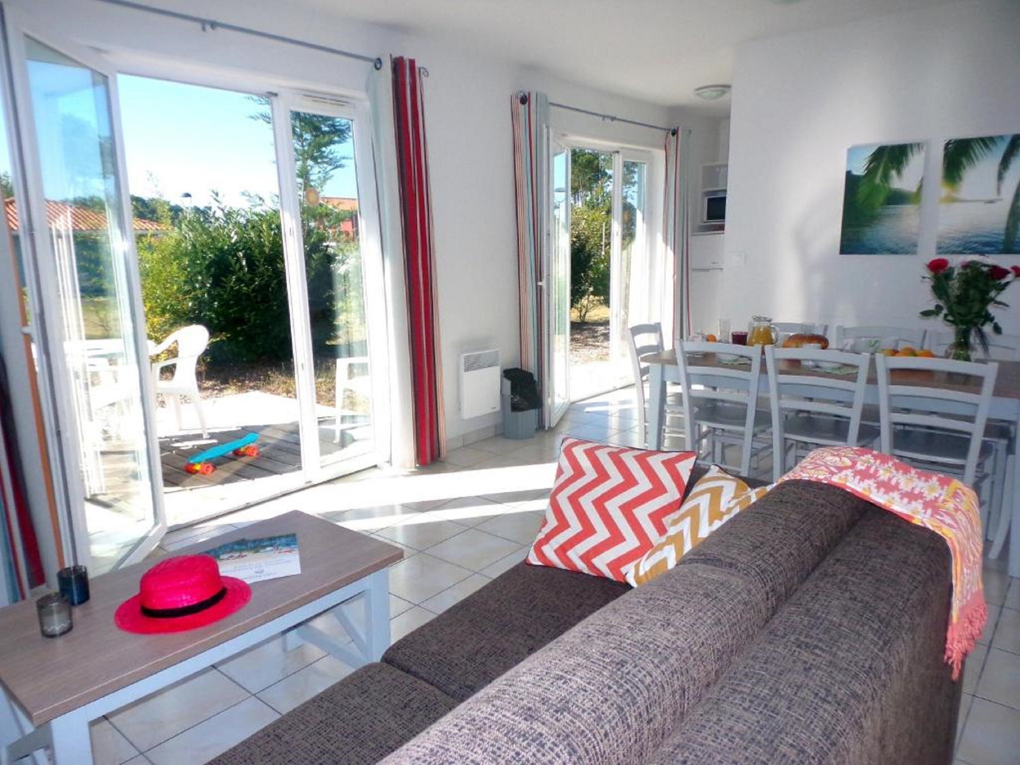 A living room with a sofa, a table, and a dining area.