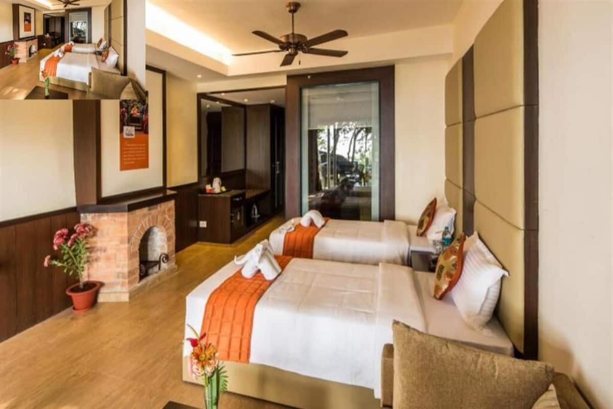 Une chambre d’hôtel avec deux lits, une cheminée, un ventilateur de plafond et une vue sur l’extérieur.