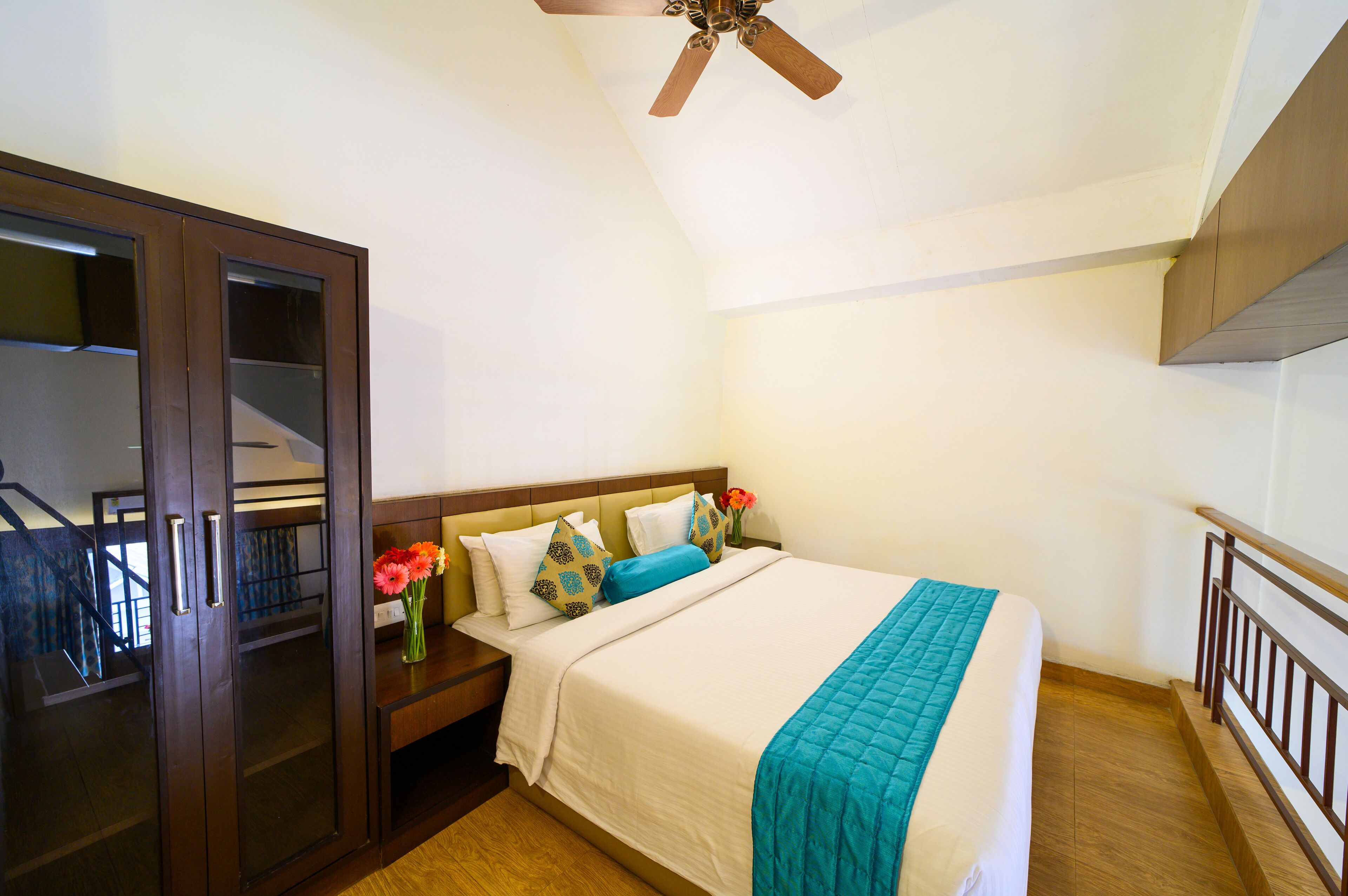 A bedroom with a bed, nightstand, dresser, and a ceiling fan.