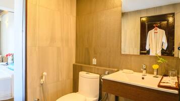 A modern bathroom with a toilet, sink, and mirror.
