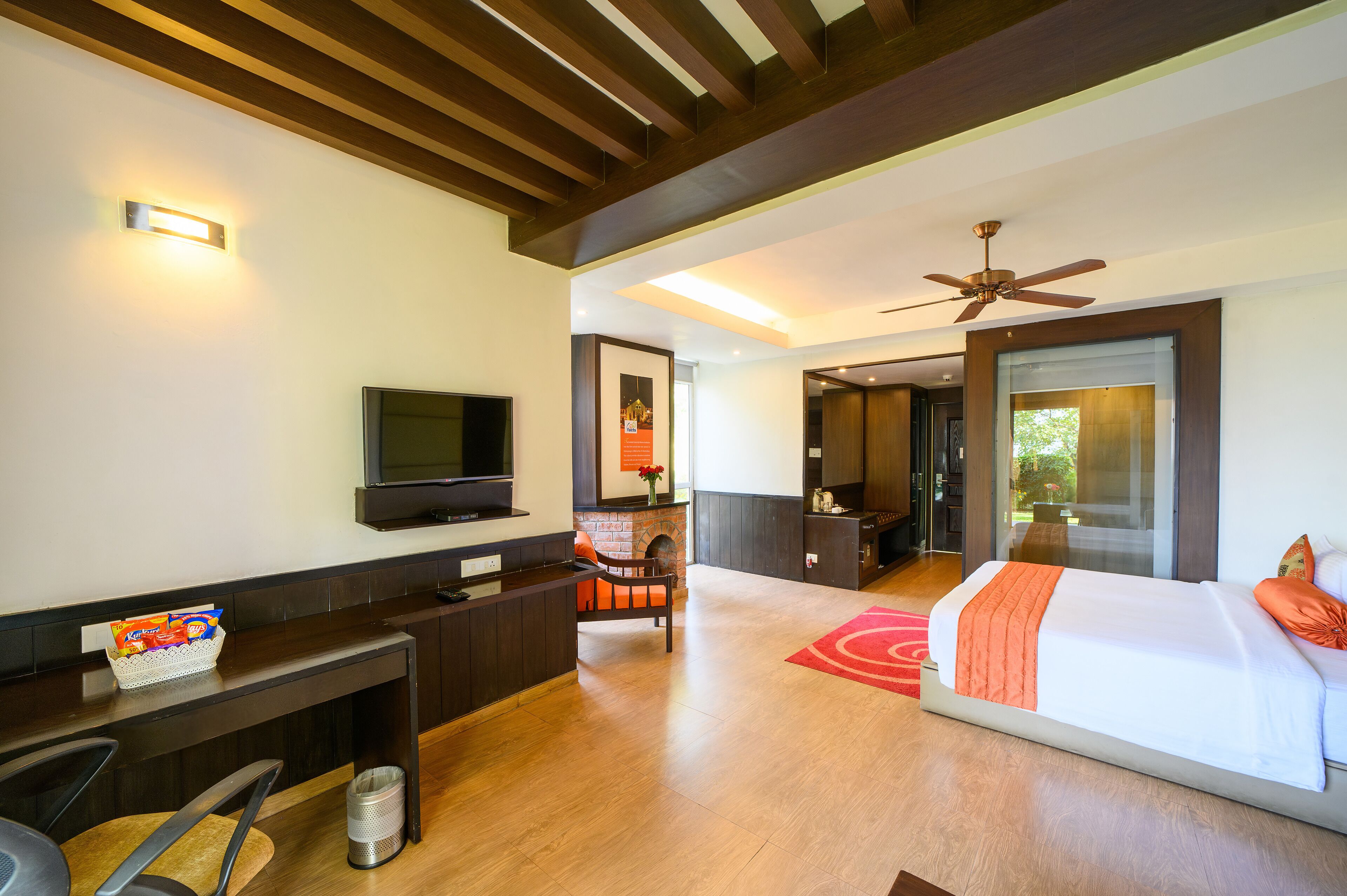 A hotel room with a bed, a TV, a desk, and a seating area.