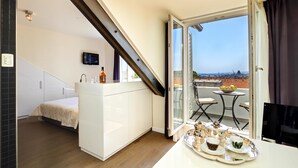 A modern hotel room with a balcony, a dining area with a tray of breakfast items, and a TV. - La Porta Luxury Rooms (Split)