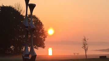 Eine Skulptur in einem Park, im Hintergrund ein Sonnenuntergang.
