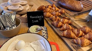 A breakfast table with croissants, bread, eggs, and a sign reading "Ramslag's Salt".