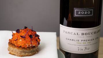 En flaske Pascal Bouchard 2020 Chablis Premier Cru Vau de Vey vin ved siden af en ret.