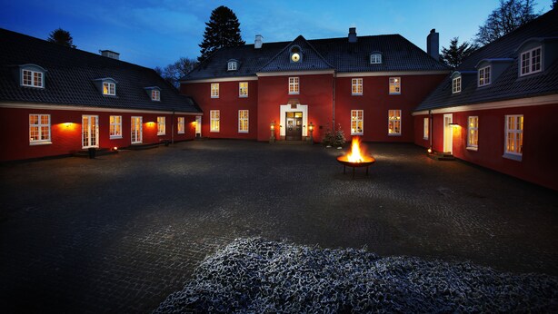 Un patio con una chimenea central, rodeado de edificios rojos con numerosas ventanas y una distribución simétrica.