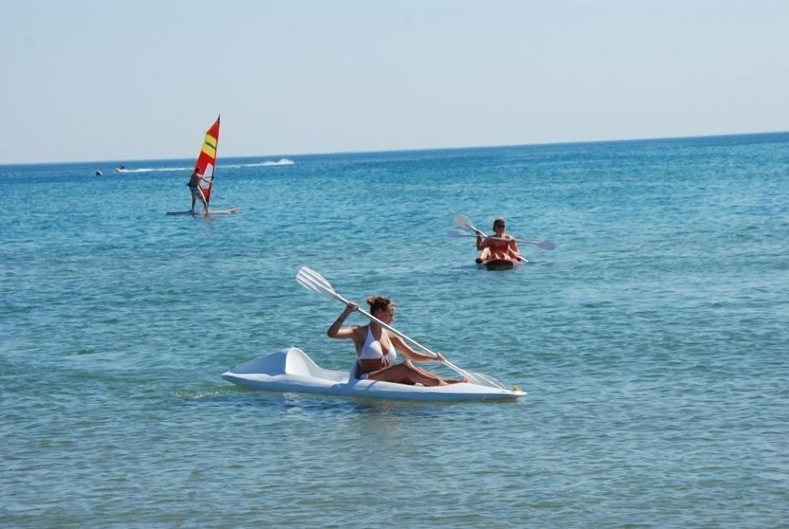 A person in a kayak on calm water.