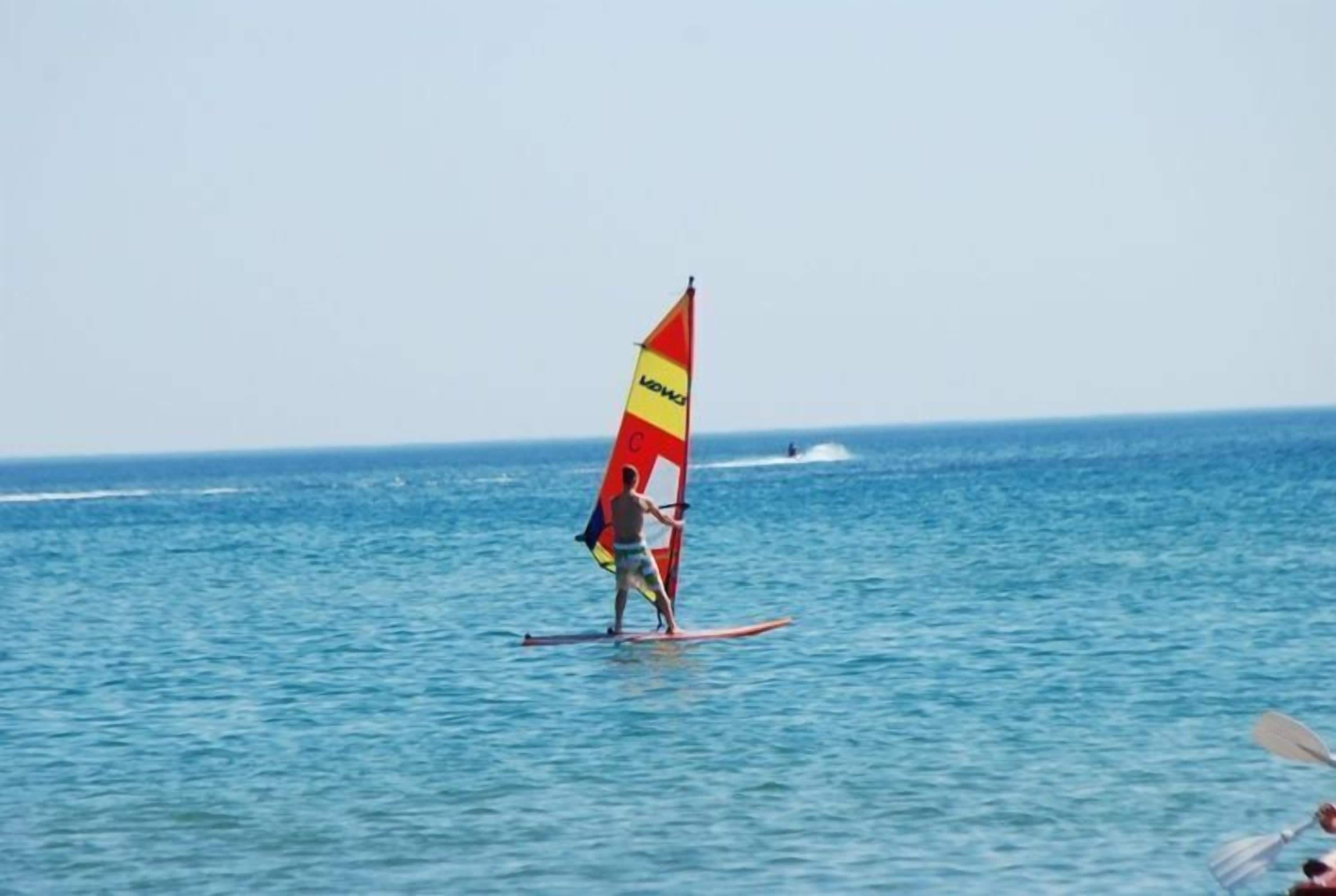 Une personne pratiquant la planche à voile par temps clair.