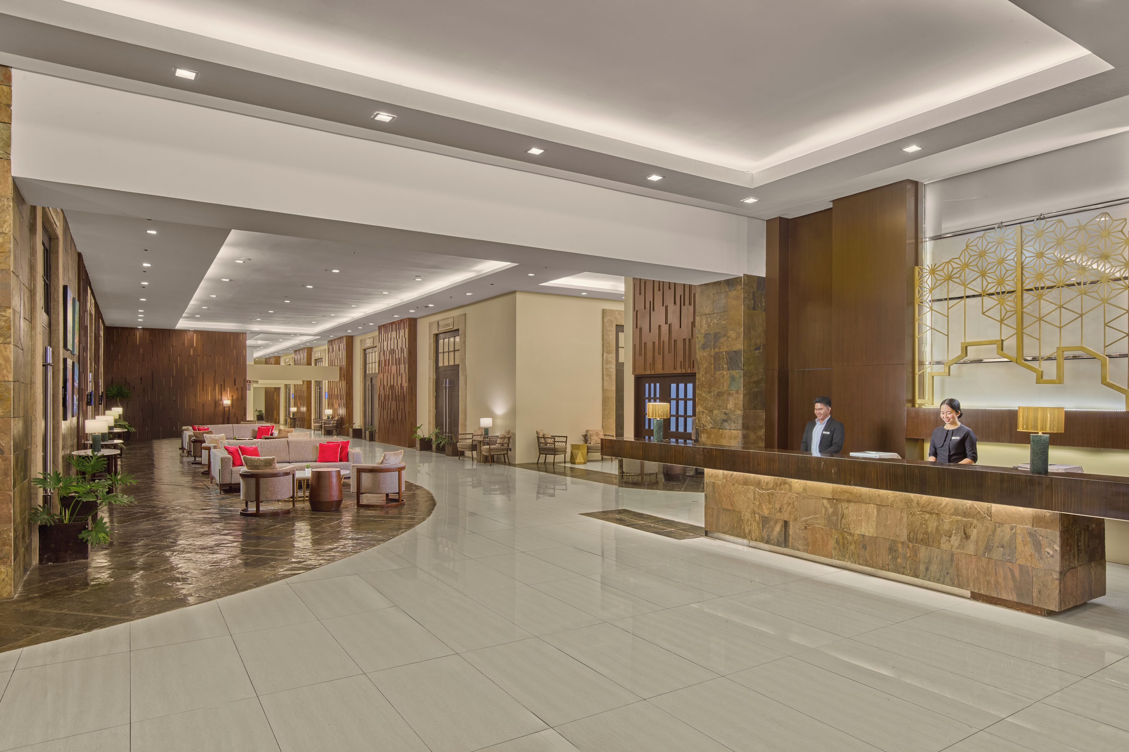 A spacious lobby with a reception desk, seating area, and a modern design.