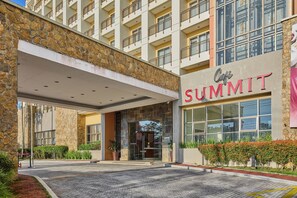 A hotel entrance with a stone facade, a covered entrance area, and a sign reading "Café Summit".