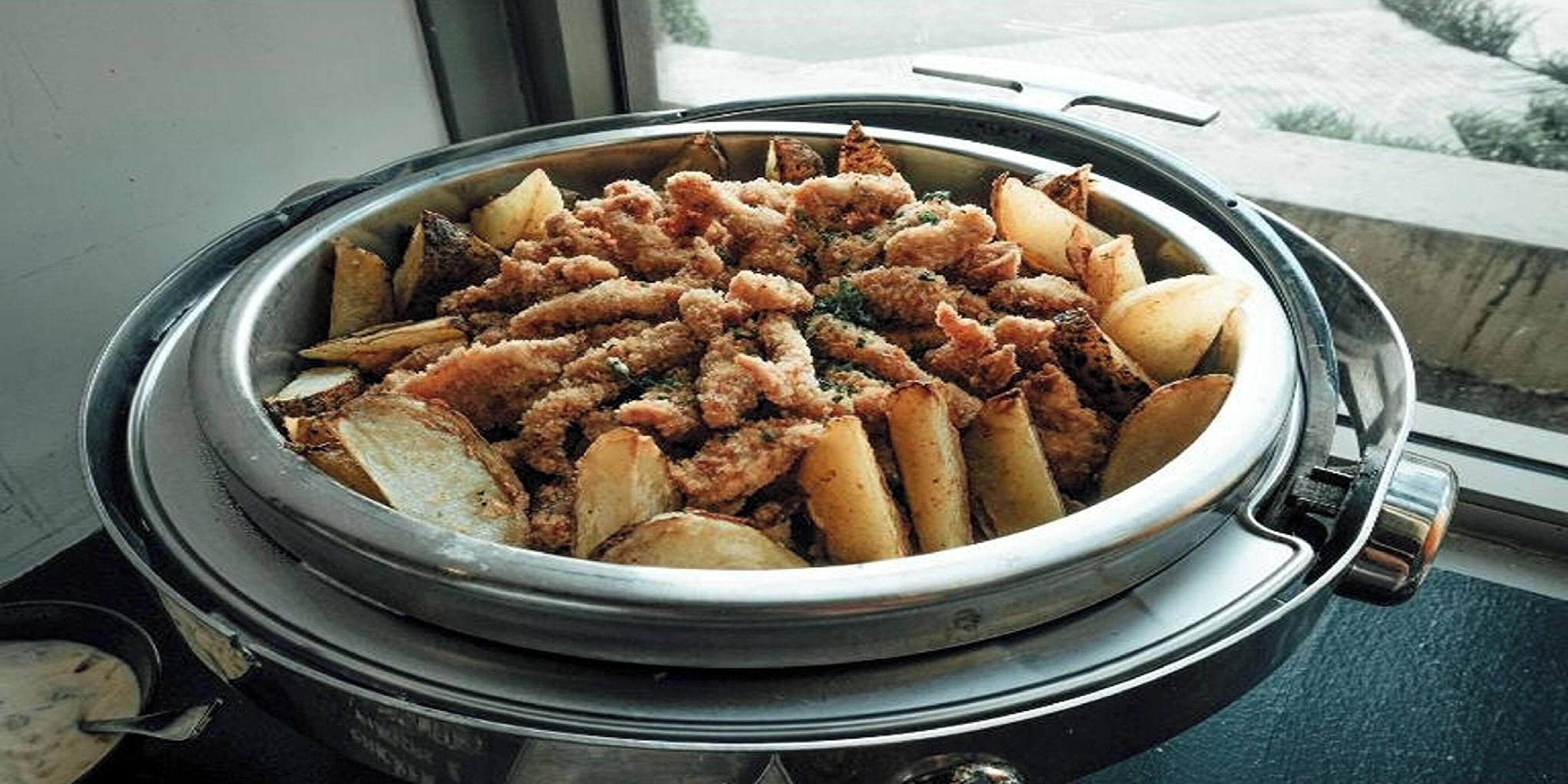 A buffet with fried chicken and potatoes.