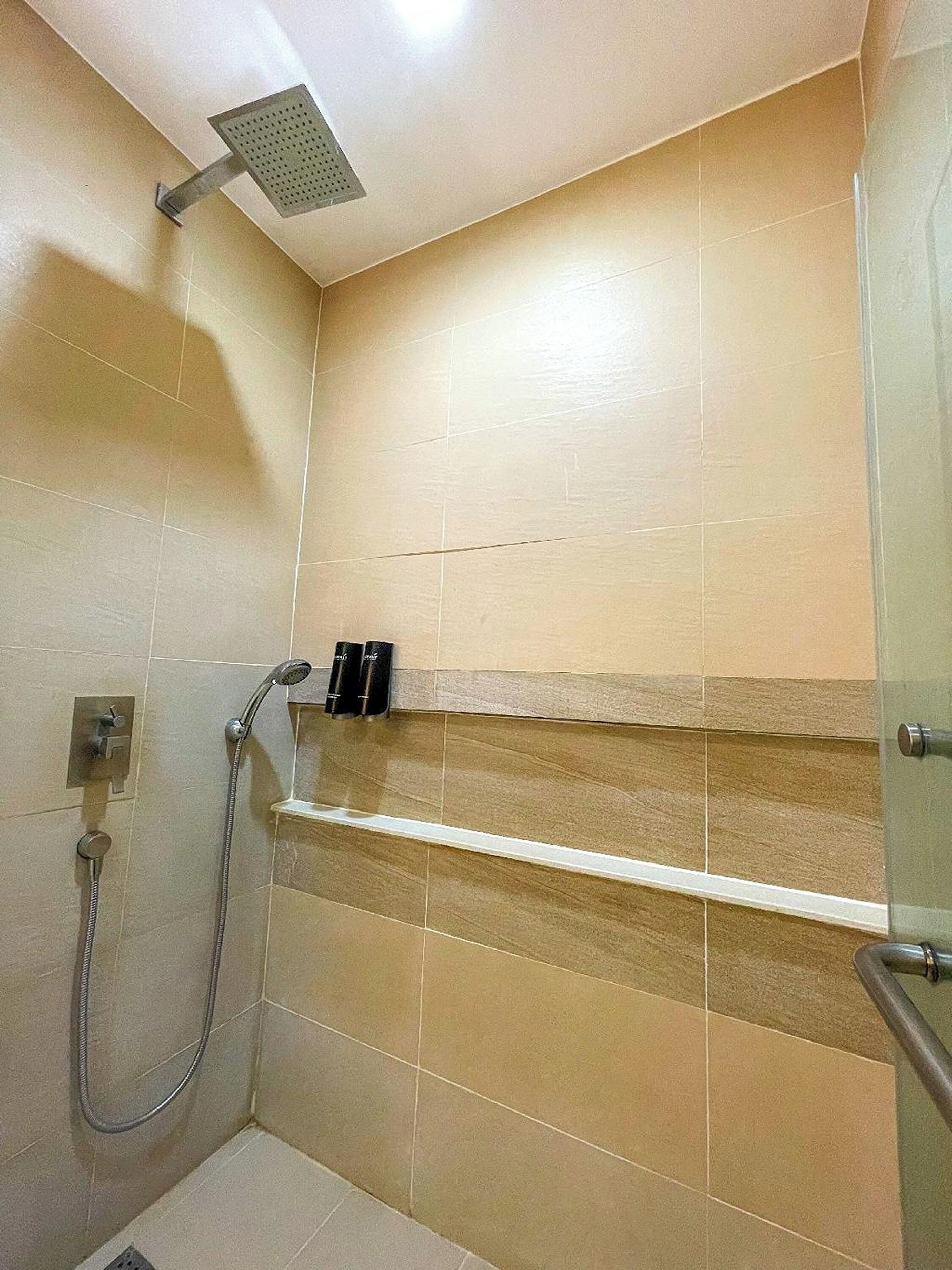 Una doccia con soffione a mano e rubinetto a muro.