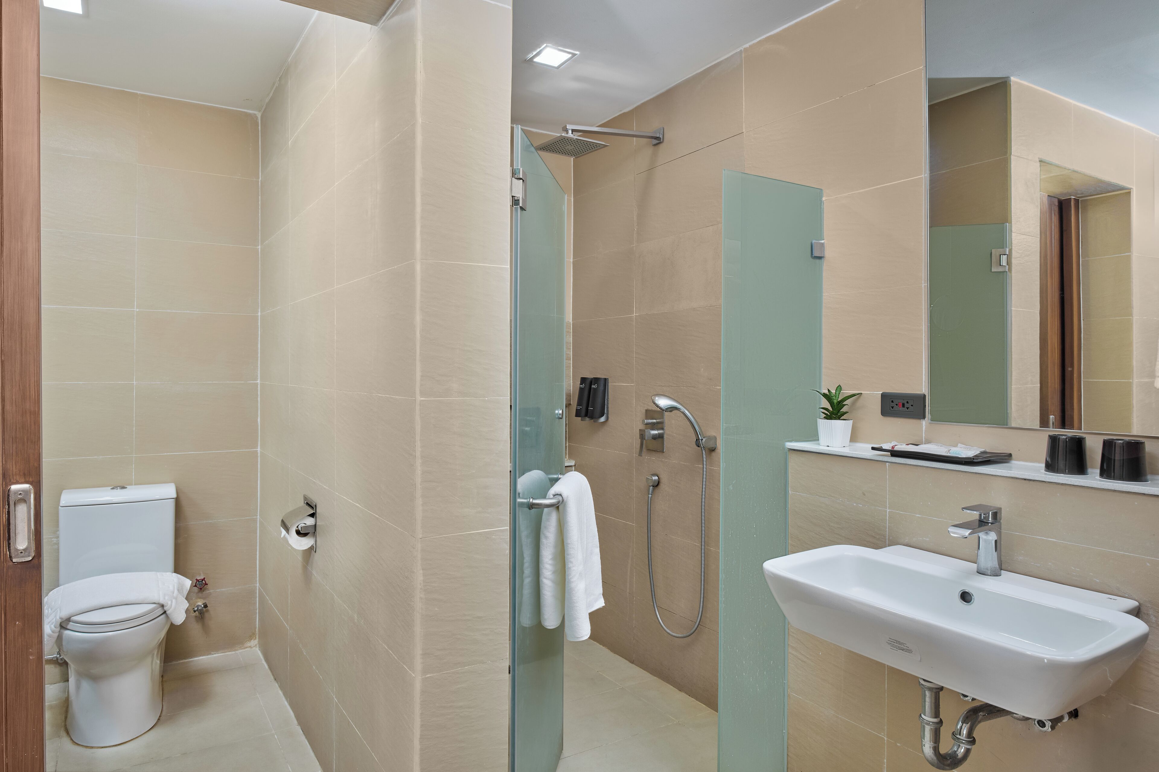 A modern bathroom with a toilet, shower, and sink.