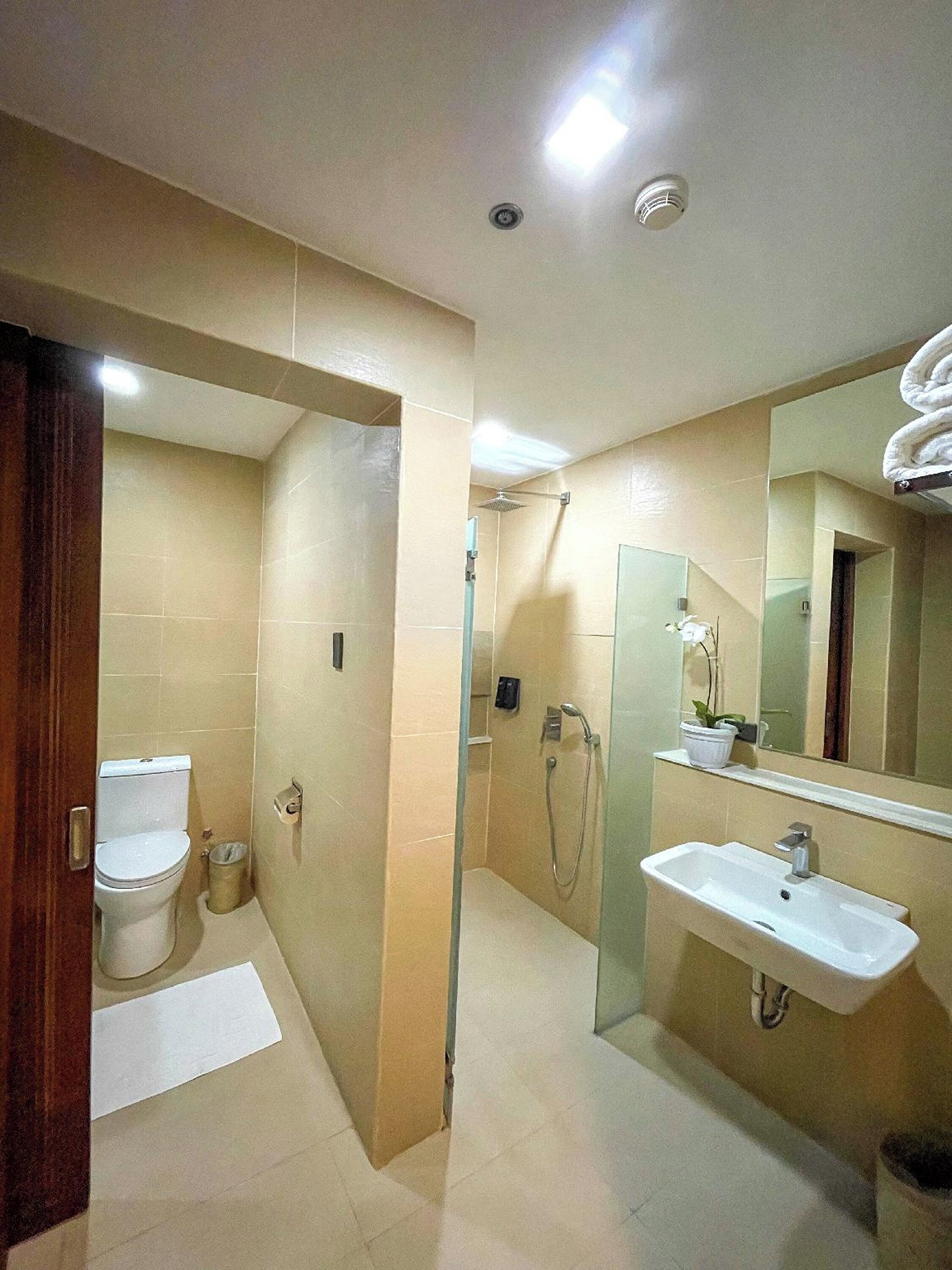 A modern bathroom with a toilet, shower, and sink.