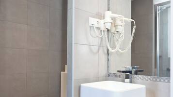 A modern bathroom with a toilet, a sink, and a shower area.
