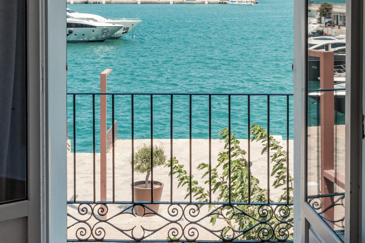 Ein Balkon mit Blick auf einen Jachthafen und Gebäude in der Ferne.