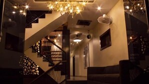 Ein modernes Interieur mit Treppe, einer Chandelieber und einem Sofa.