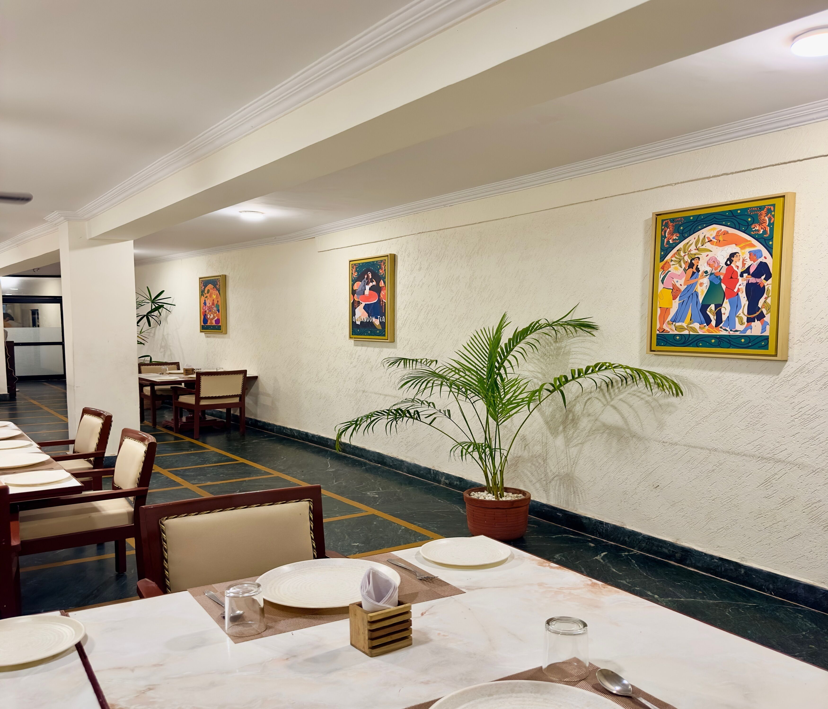 Un restaurante con suelos de mármol, sillas de madera, mesas dispuestas con platos y cubiertos, y decoración en las paredes.