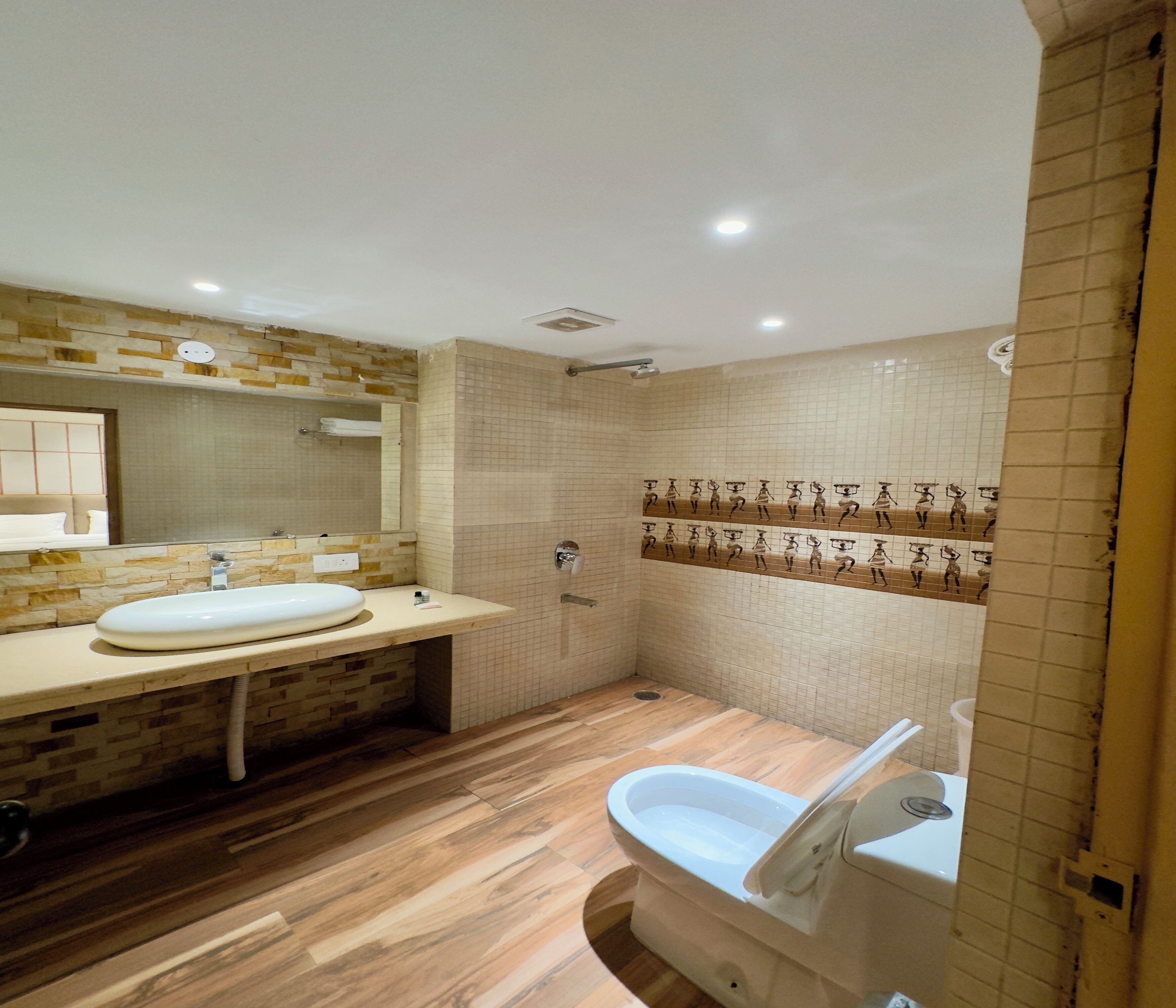 Un baño moderno con un lavamanos grande, un espejo y una zona de ducha.