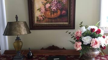 A desk with a lamp, a book, and a vase of flowers.