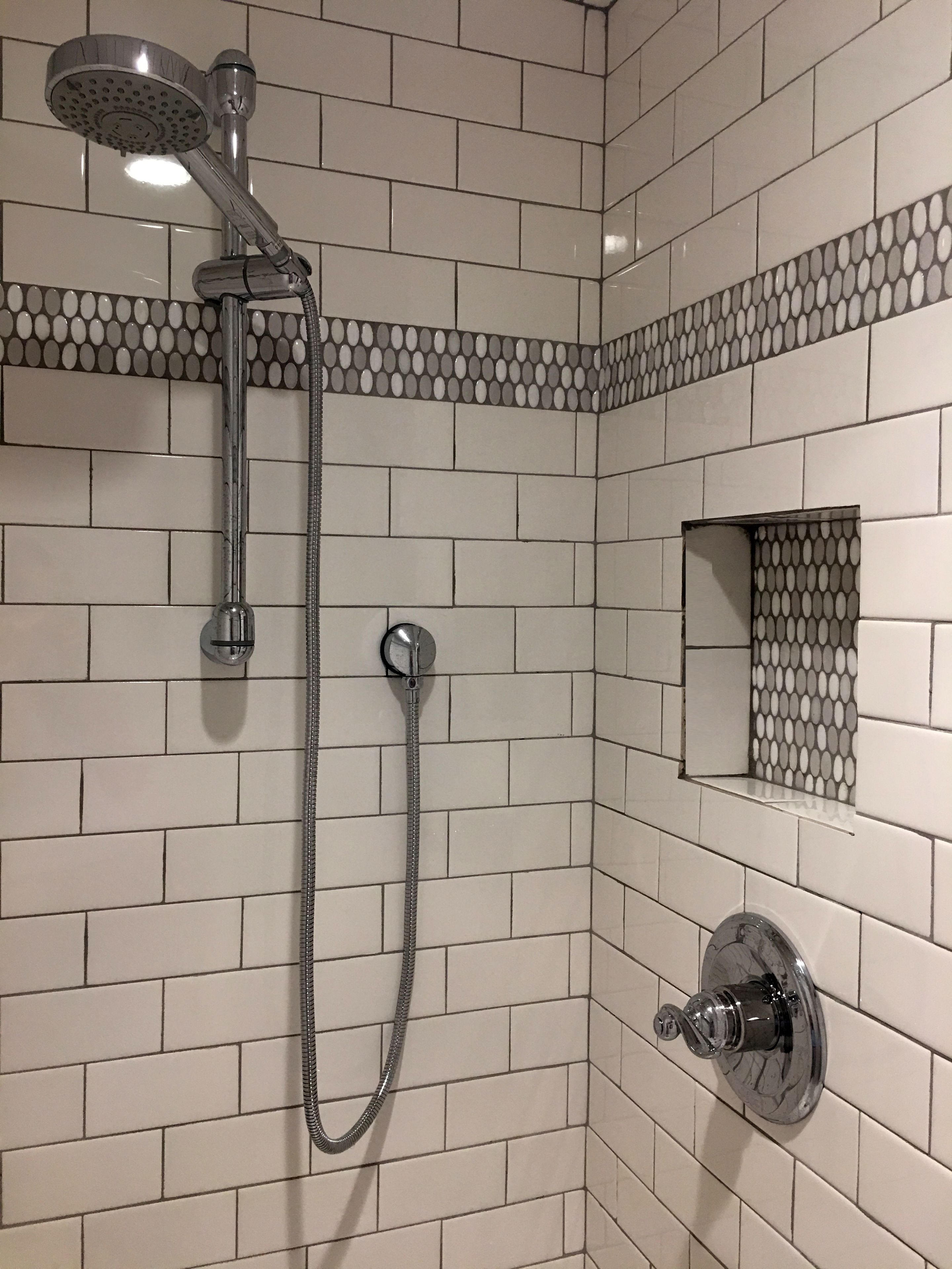 A shower with a handheld showerhead and a wall-mounted faucet.