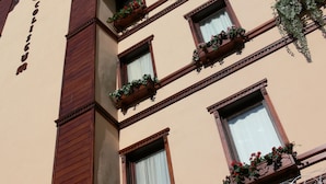 Un edifici amb diverses finestres, algunes amb balcons florals.