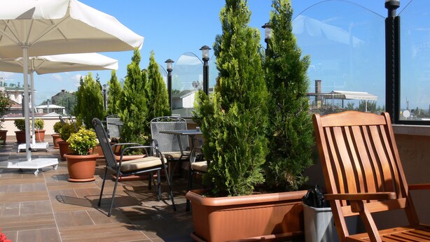 Terrassa amb seients a l'aire lliure, plantes en testos i vista a la ciutat.