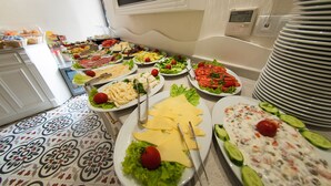 Un bufet de l'allotjament amb diferents plats, incloses amanides, formatges i un plat cremós amb cogombre.