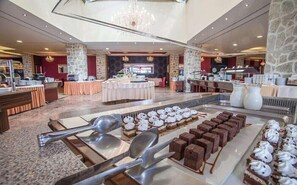 A buffet setup with various desserts and utensils.
