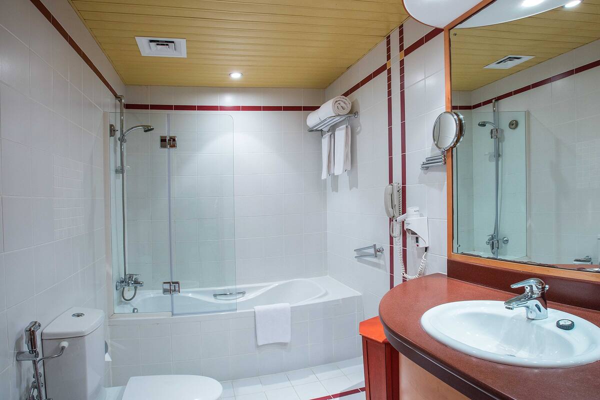 Un bagno moderno con doccia vetrata, una vasca freestanding e un mobile lavabo con lavandino e specchio.