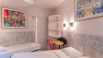 Ein Hotelzimmer mit zwei Betten, einem Schreibtisch, einem Sessel und einem großen Gemälde an der Wand.