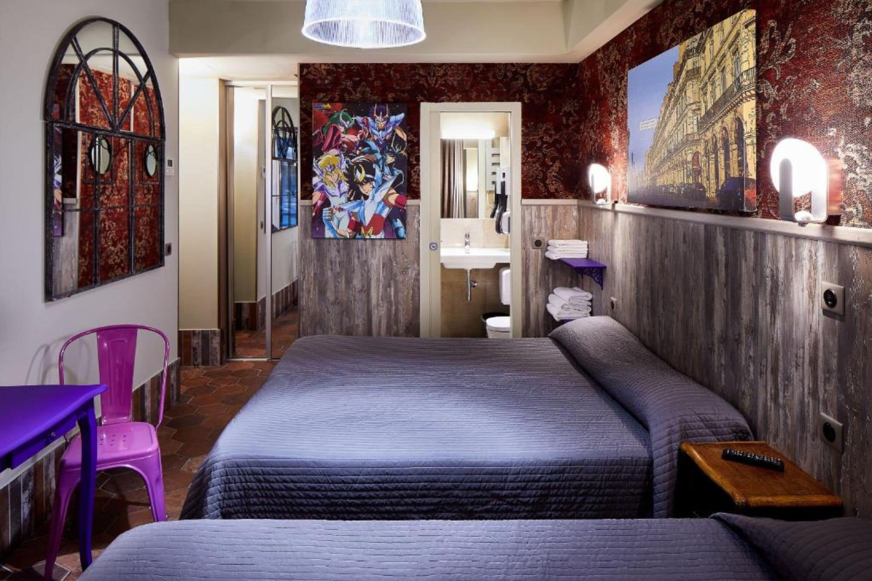 A bedroom with two beds, a bathroom with a mirror, and a hallway leading to another room.
