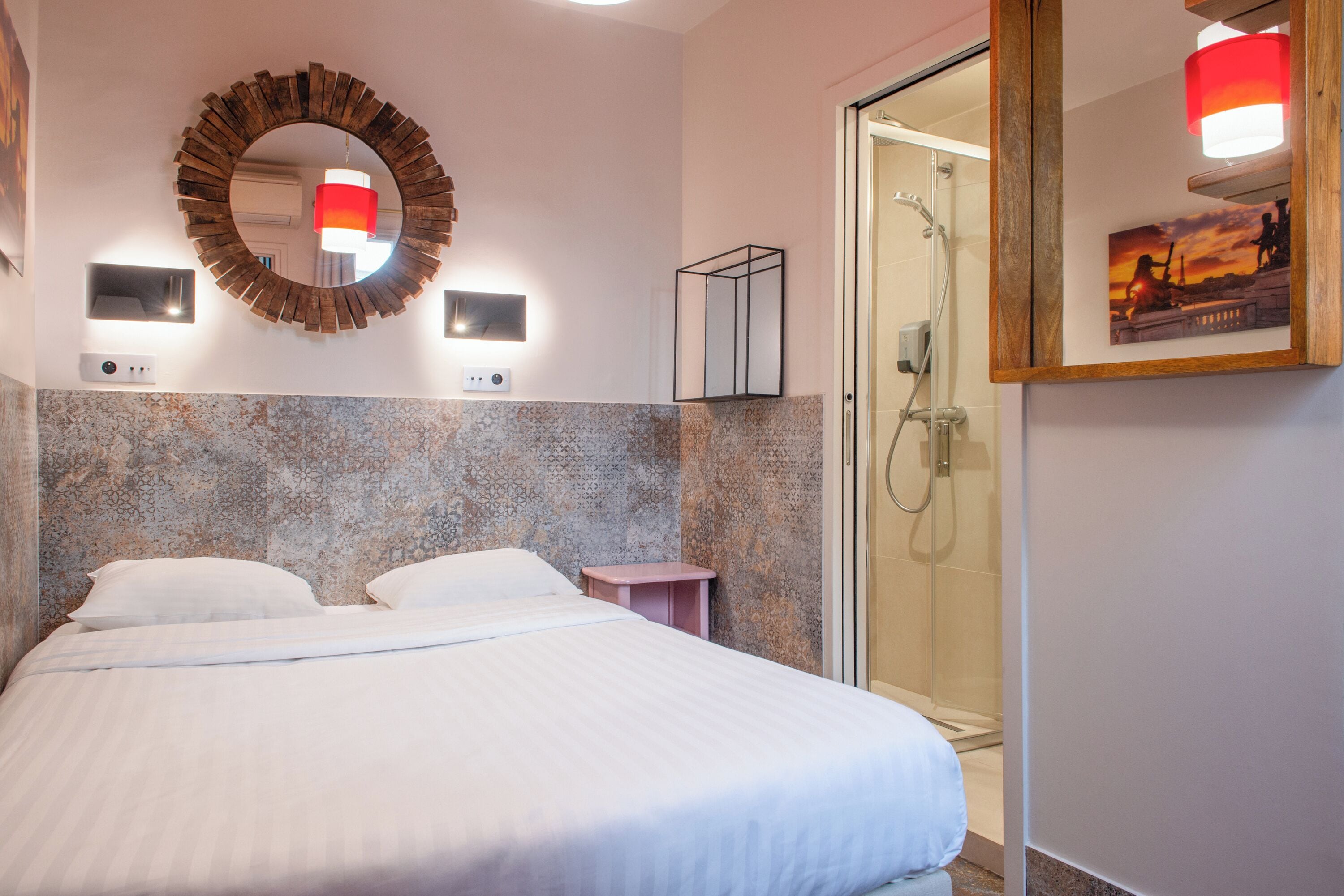 Een hotelkamer met een groot bed, een douche en een spiegel aan de muur.