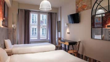 Une chambre d’hôtel avec deux lits, un bureau, une chaise, une télévision et une fenêtre avec des rideaux.