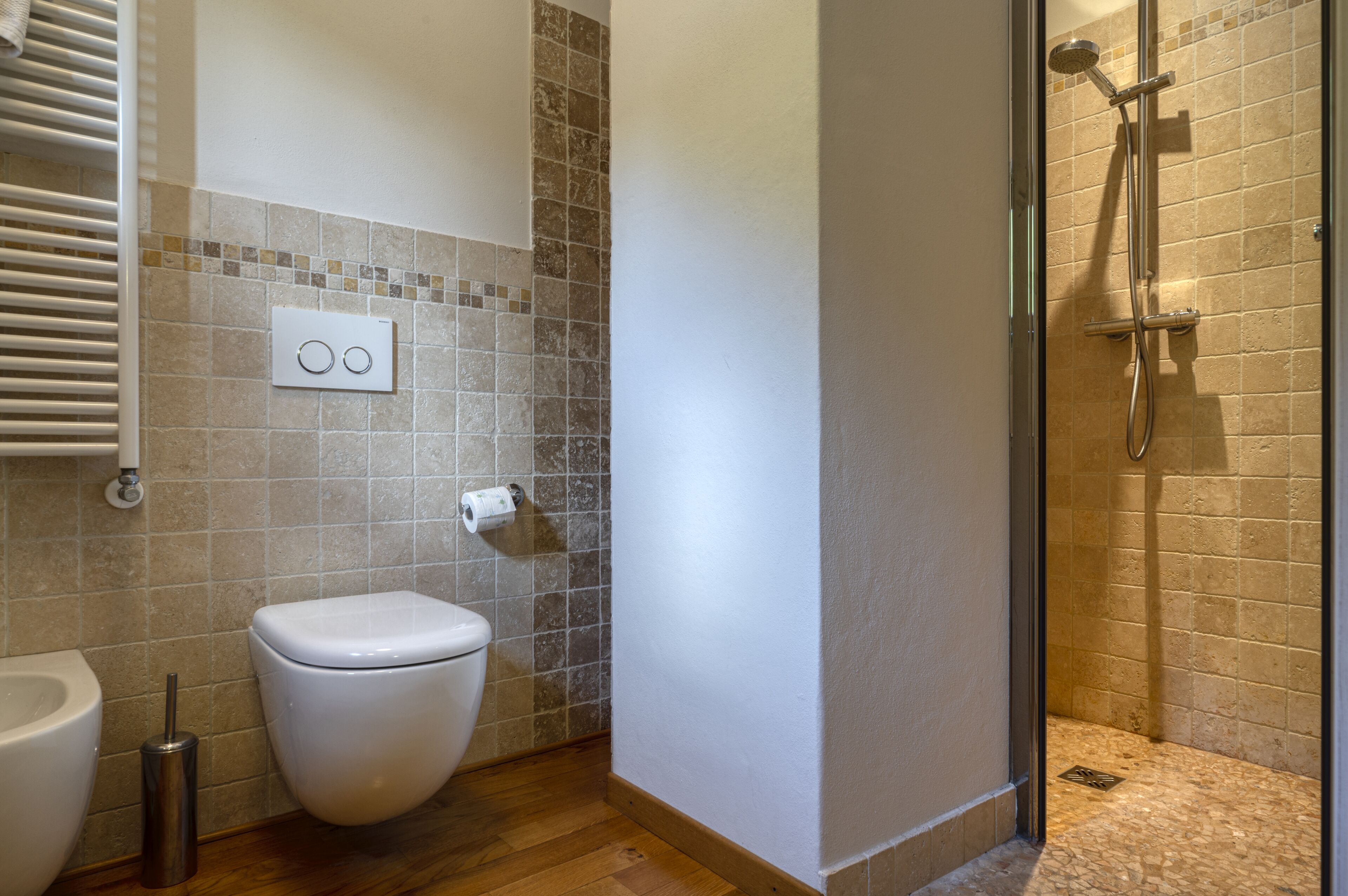 A bathroom with a toilet, a bidet, and a shower area.